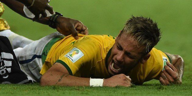 Brazil's forward Neymar (C) lies on the pitch after being injured during the quarter-final football match between Brazil and Colombia at the Castelao Stadium in Fortaleza during the 2014 FIFA World Cup on July 4, 2014. AFP PHOTO / EITAN ABRAMOVICH (Photo credit should read EITAN ABRAMOVICH/AFP/Getty Images)