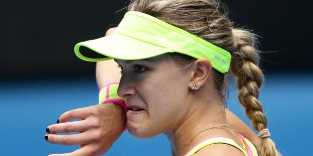 Eugenie Bouchard of Canada wipes the sweat from the face as she plays Maria Sharapova of Russia during their quarterfinal match at the Australian Open tennis championship in Melbourne, Australia, Tuesday, Jan. 27, 2015. (AP Photo/Rob Griffith)