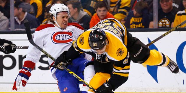 Montreal Canadiens' P.A. Parenteau, left, is checked by Boston Bruins' Patrice Bergeron during the first period of an NHL hockey game in Boston, Saturday, Nov. 22, 2014. (AP Photo/Winslow Townson)