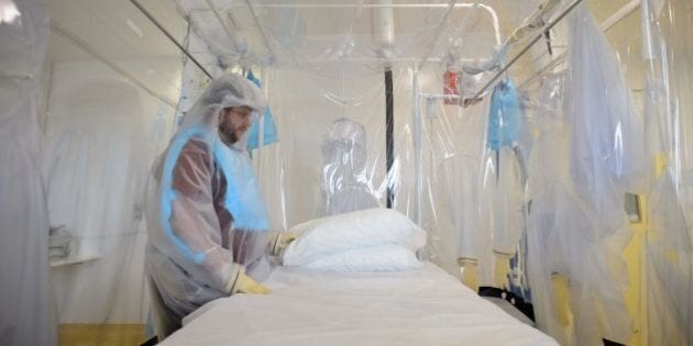 A nurse wears protective clothing as he demonstrates the facilities in place at the Royal Free Hospital in north London on August 6, 2014, in preparation for a patient testing positive for the Ebola virus. The specialised unit allows a team of doctors and nurses to provide care for anyone with the contagious condition. Despite it's high mortality level, Consultant Stephen Mepham advised against panic, stating that the chances of meeting an undiagnosed patient are virtually impossible with next to no chance of catching the virus without exposure to the sufferer's bodily fluids. AFP PHOTO/Leon Neal (Photo credit should read LEON NEAL/AFP/Getty Images)