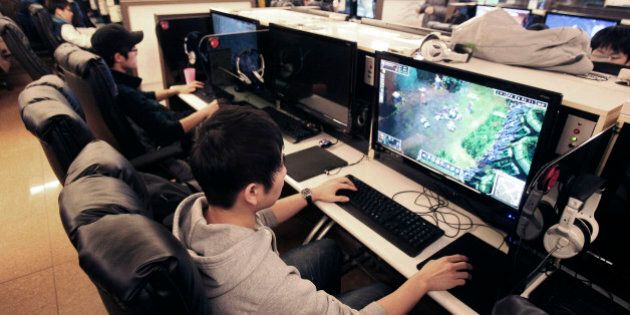 Shin Minchul, bottom, a 21-year-old college student, plays online computer games at an Internet cafe in Seoul, South Korea, Wednesday, Dec. 11, 2013. A law under consideration in South Korea's parliament has sparked vociferous debate by grouping popular online games such as