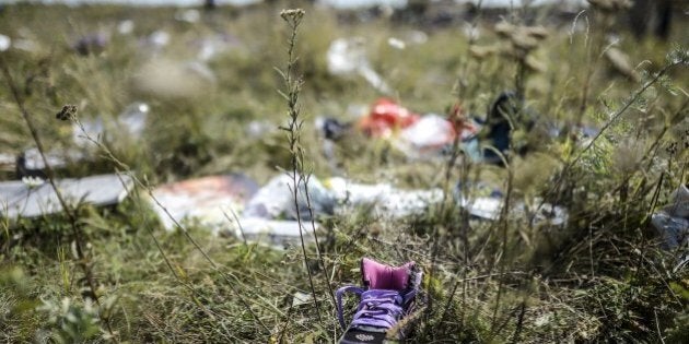 Belongings of victims are pictured at the crash site of the Malaysia Airlines flight MH17 in a field near the village of Grabove, in the Donetsk region, on July 23, 2014. The first bodies from flight MH17 arrived in the Netherlands on July 23 almost a week after it was shot down over Ukraine, with grieving relatives and the king and queen solemnly receiving the as yet unidentified victims. AFP PHOTO/ BULENT KILIC (Photo credit should read BULENT KILIC/AFP/Getty Images)