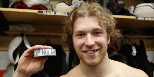 PHILADELPHIA, PA - DECEMBER 19: Claude Giroux #28 of the Philadelphia Flyers poses with his 100th NHL goal puck after his game against the Columbus Blue Jackets on December 19, 2013 at the Wells Fargo Center in Philadelphia, Pennsylvania. Giroux scored 2 goals in the third period and the Flyers went on to defeat the Blue Jackets 5-4. (Photo by Len Redkoles/NHLI via Getty Images)