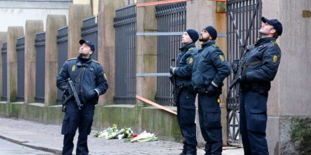 Danish police officers stand outside of a synagogue, Sunday, Feb. 15, 2015, where a gunman opened fire in Copenhagen, Denmark. Danish police shot and killed a man early Sunday suspected of carrying out shooting attacks at a free speech event and then at a Copenhagen synagogue, killing two men, including a member of Denmark's Jewish community. Five police officers were also wounded in the attacks. (AP Photo/Michael Probst)