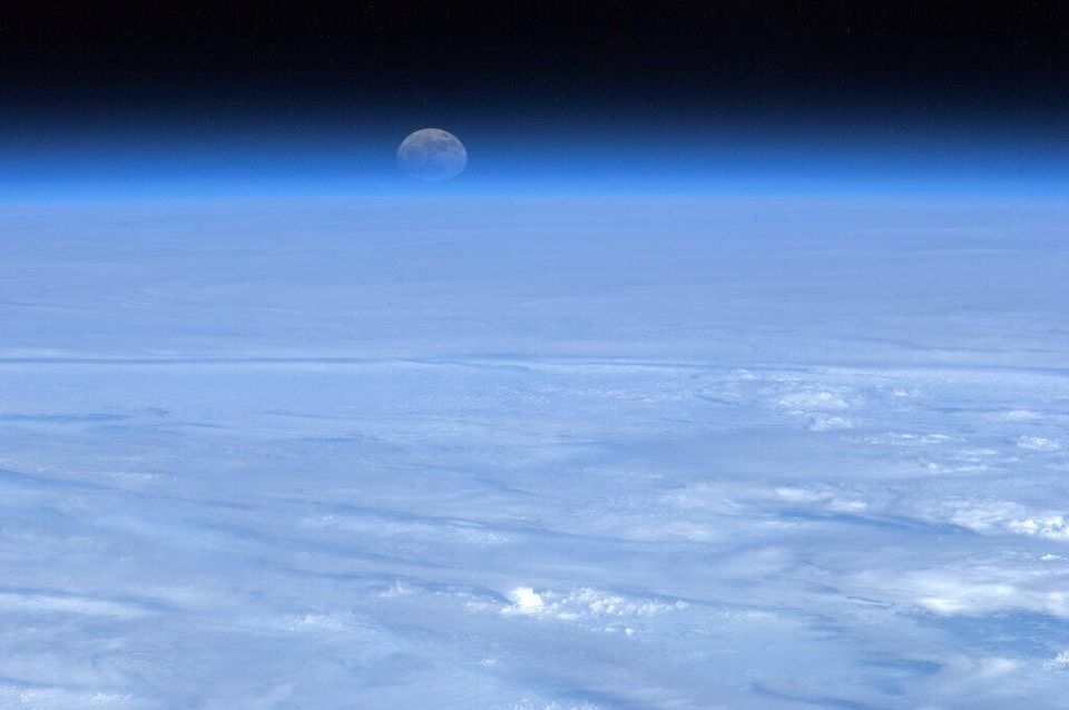 The moon rising over a bed of cloud 