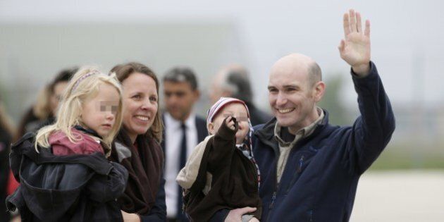 Nicolas Henin (C) waves after reuniting with his family upon his arrival with the three other French journalists taken hostage in Syria last year and freed yesterday, at the Villacoublay air base southwest of Paris on April 20, 2014. The journalists Didier Francois, Edouard Elias, Nicolas Henin and Pierre Torres had been captured in two separate incidents in June last year while covering the conflict in Syria. AFP PHOTO / KENZO TRIBOUILLARD (Photo credit should read KENZO TRIBOUILLARD/AFP/Getty Images)