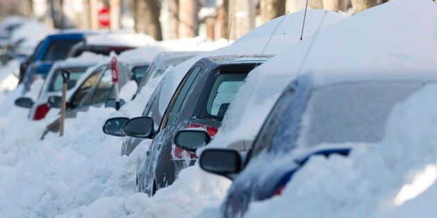 Cars are shown buried in snow in Montreal, Friday, Dec. 28, 2012, following the first major snowstorm of winter in the region. THE CANADIAN PRESS/Graham Hughes