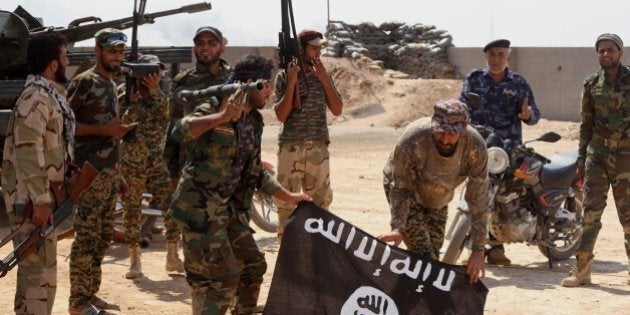 Iraqi security forces hold a flag of the Islamic State group they captured during an operation outside Amirli, some 105 miles (170 kilometers) north of Baghdad, Iraq, Monday, Sept. 1, 2014. Aid began flowing into the small northern Shiite town in Iraq on Monday, a day after security forces backed by Iran-allied Shiite militias and U.S. airstrikes broke a two-month siege by insurgents in a rare victory by government forces. (AP Photo)