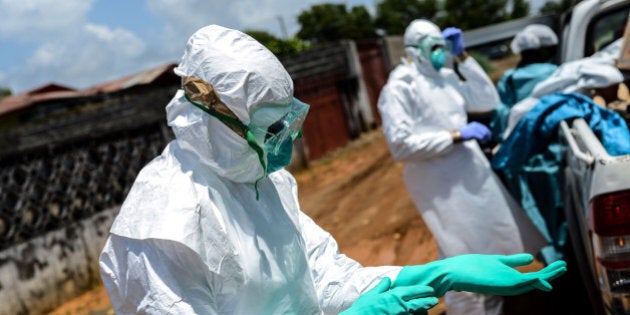 MONROVIA, LIBERIA - OCTOBER 10: A Red Cross member wears special uniform before carrying the body of 36 aged Hanfen John who died due to the Ebola virus, in Monrovia, Liberia on 10 October, 2014. (Photo by Mohammed Elshamy/Anadolu Agency/Getty Images)