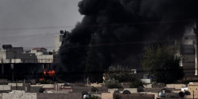 A picture taken in the southeastern village of Mursitpinar, on October 10, 2014 shows smoke rising from the Syrian town of Ain al-Arab, known as Kobane by the Kurds. AFP PHOTO / ARIS MESSINIS (Photo credit should read ARIS MESSINIS/AFP/Getty Images)