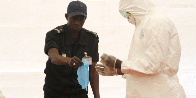 A Senegalese hygienist demonstrates how to protect oneself against the Ebola virus on April 8, 2014 at Dakar airport, during a visit of the Senegalese health minister to check the safety measures put in place to fight against the virus' spread in western Africa. West Africa's Ebola outbreak is among the 'most challenging' ever to strike since the disease emerged four decades ago, the World Health Organisation (WHO) said on April 8, as the suspected death toll from the virus hit 111. AFP PHOTO / SEYLLOU (Photo credit should read SEYLLOU/AFP/Getty Images)