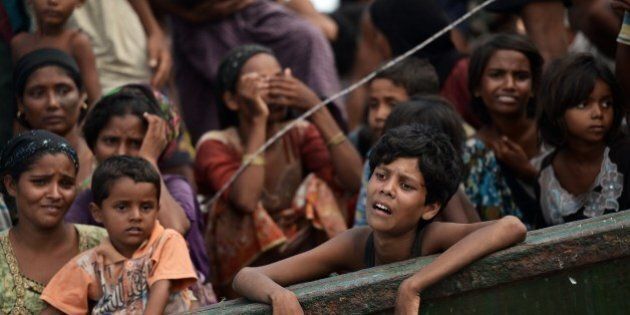 Rohingya migrants stand and sit on a boat drifting in Thai waters off the southern island of Koh Lipe in the Andaman sea on May 14, 2015. The boat crammed with scores of Rohingya migrants -- including many young children -- was found drifting in Thai waters on May 14, according to an AFP reporter at the scene, with passengers saying several people had died over the last few days. AFP PHOTO / Christophe ARCHAMBAULT (Photo credit should read CHRISTOPHE ARCHAMBAULT/AFP/Getty Images)