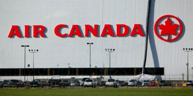 Cars sit parked in front of the Air Canada hanger at Vancouver International Airport (YVR) in Richmond, British Columbia, Canada, on Wednesday, Nov. 13, 2013. The number of international visitors to Canada plunged 20 per cent since 2000 even as global travel soars, according to a sobering report being released Thursday by Deloitte Canada. Photographer: Ben Nelms/Bloomberg via Getty Images