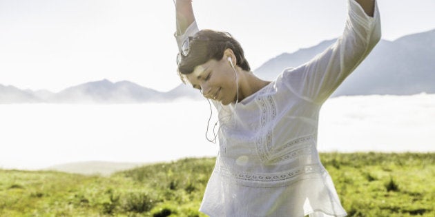 Young woman dancing in field, Tyrol, Austria