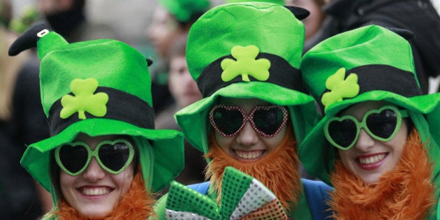 People dress in the emerald green to honour Ireland's Saint Partick, as they enjoy the atmosphere during the St Patrick's day parade in Dublin, Ireland, March, 17, 2014. The world's largest parade celebrating Irish heritage set off on a cold and gray morning, the culmination of a weekend of St. Patrick's Day revelry. (AP Photo/Peter Morrison)