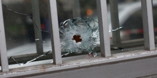 A bullet impact is seen in a window of a building next to the French satirical newspaper Charlie Hebdo's office, in Paris, Wednesday, Jan. 7, 2015. Masked gunmen shouting