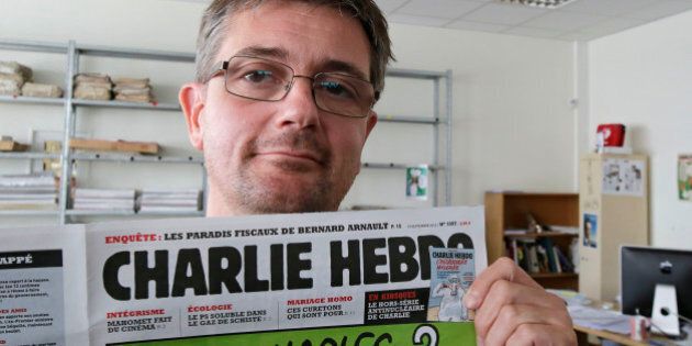 Publishing director of the satyric weekly Charlie Hebdo, Charb, displays the front page of the newspaper as he poses for photographers in Paris, Wednesday, Sept. 19, 2012. Police took up positions outside the Paris offices of the satirical French weekly that published crude caricatures of the Prophet Muhammad on Wednesday that ridicule the film and the furor surrounding it. The provocative weekly, Charlie Hebdo, was firebombed last year after it released a special edition that portrayed the Prophet Muhammad as a
