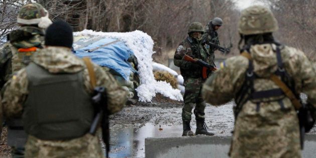 Ukrainian government army soldiers at a check-point near the village of Debaltseve, Donetsk region, eastern Ukraine Wednesday, Dec 24, 2014. Peace talks aimed at reaching a stable cease-fire in Ukraine between its government forces and pro-Russian armed groups began on Wednesday in Minsk, Belarus, with the discussions to include a pullout of heavy weapons and an exchange of war prisoners. (AP Photo/Sergei Chuzavkov)
