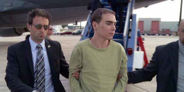 In this photo provided by Montreal Police, Luka Rocco Magnotta is taken by police from a Canadian military plane to a waiting van on Monday, June 18, 2012, in Mirabel, Quebec. Magnotta, the suspect in the killing and dismemberment of a Chinese student, returned to Canada via military transport from Germany, where he was arrested this month. (AP Photo/Montreal Police)