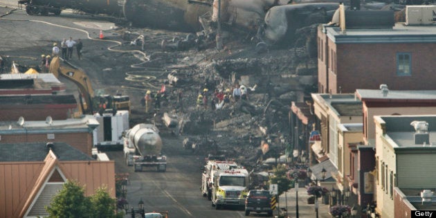 LAC-MEGANTIC QC - JULY 8: Search teams carry a large white bag out of the rubble in the town centre of Lac-MÈgantic during their search for the dead Monday evening. 40 more are missing after a train derailment caused a massive explosion early Saturday morning. (Lucas Oleniuk/Toronto Star via Getty Images)