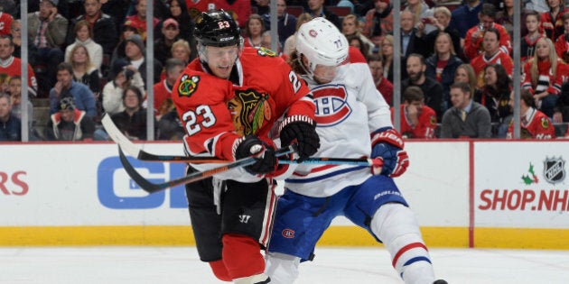 CHICAGO, IL - DECEMBER 05: Kris Versteeg #23 of the Chicago Blackhawks and Tom Gilbert #77 of the Montreal Canadiens battle for the puck during the NHL game at the United Center on December 5, 2014 in Chicago, Illinois. (Photo by Bill Smith/NHLI via Getty Images)