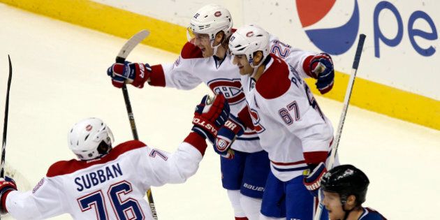 Montreal Canadiens defenseman P.K. Subban, 76, celebrates with right wing Dale Weise, 22, and left wing Max Paciorety, 67, after he scored against the Colorado Avalanche in the third period of the Canadiens' 4-3 victory in an NHL hockey game in Denver on Monday, Dec. 1, 2014. Avalanche left wing Gabriel Landeskog, right, of Sweden, looks on. (AP Photo/David Zalubowski)