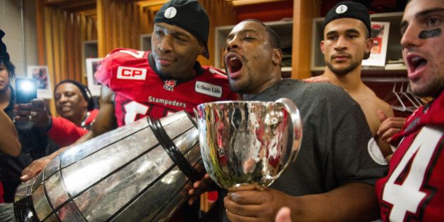 VANCOUVER, BC - NOVEMBER 30: Maurice Price #17 of the Calgary Stampeders (left) and Anthony Parker #86 celebrates with the Grey Cup in the dressing room after it broke into two pieces after defeating the the Hamilton Tiger-Cats in the 102nd Grey Cup Championship Game at BC Place November 30, 2014 in Vancouver, British Columbia, Canada. (Photo by Rich Lam/Getty Images)