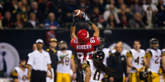 VANCOUVER, BC - NOVEMBER 30: Eric Rogers #80 of the Calgary Stampeders makes a catch while being defended against by Rico Murray #0 of the Hamilton Tiger-Cats during the first half of the 102nd Grey Cup Championship Game at BC Place November 30, 2014 in Vancouver, British Columbia, Canada. (Photo by Rich Lam/Getty Images)