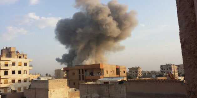 RAQQA, SYRIA - NOVEMBER 25 : Smoke rises after air strikes by Syrian army warplanes on the ISIL-held northern city of Raqqa, Syria on November 25, 2014. At least 130 people have been killed when Syrian war planes struck in Raqqa. (Photo by Stringer/Anadolu Agency/Getty Images)