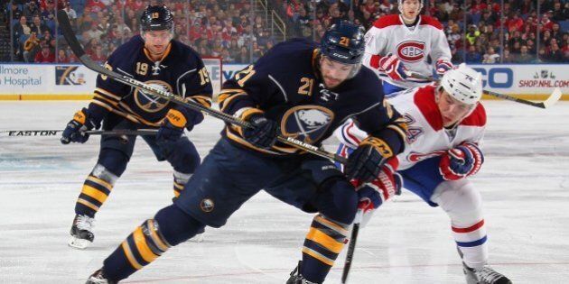 BUFFALO, NY - NOVEMBER 28: Drew Stafford #21 of the Buffalo Sabres and Alexei Emelin #74 of the Montreal Canadiens battle for the puck on November 28, 2014 at the First Niagara Center in Buffalo, New York. (Photo by Bill Wippert/NHLI via Getty Images)