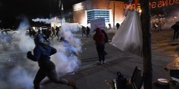 Demonstrators flee as police fire tear gas during a demonstration to protest the death 18-year-old Michael Brown in Ferguson, Missouri, on November 24, 2014. US President Barack Obama urged calm on November 24 as violent protests broke out on the streets of Ferguson after a grand jury decided a white policeman will not face charges for killing a black teen. AFP PHOTO/Jewel Samad (Photo credit should read JEWEL SAMAD/AFP/Getty Images)