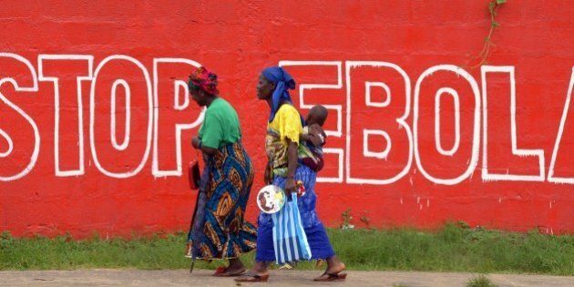 Women walk past a slogan painted on a wall reading 'Stop Ebola' in Monrovia on August 31, 2014. Liberia on August 30, 2014 said it would deny permission for any crew to disembark from ships at the country's four seaports until the Ebola epidemic ravaging west Africa was under control. AFP PHOTO/DOMINIQUE FAGET (Photo credit should read DOMINIQUE FAGET/AFP/Getty Images)
