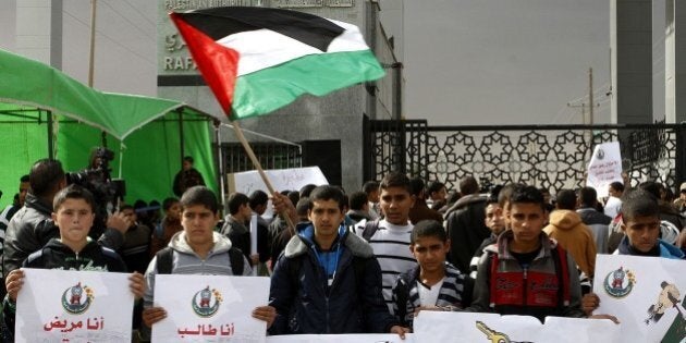 RAFAH, GAZA - NOVEMBER 23: A group of Palestinian students hold banners as they stage demonstration against Egyptian Government to show their demand to re-open border crossing in Rafah, Gaza on November 23, 2014. (Photo by Abed Rahim Khatib/Anadolu Agency/Getty Images)