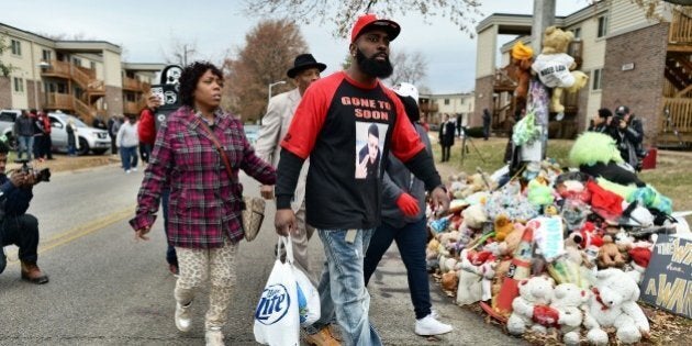 Michael Brown Sr. (C), the father of 18-year-old Michael Brown who was shot dead by a police officer, distributes turkey for Thanksgiving to neighbors where his son was killed in Ferguson, Missouri, on November 22, 2014. Tensions rose Saturday in the troubled St Louis suburb of Ferguson, with a grand jury poised to decide whether to prosecute a white police officer for killing an unarmed black teenager. US President Barack Obama has called for calm, Missouri's governor declared a state of emergency and activated the state National Guard, and the FBI has deployed an extra 100 personnel in the city.Police helicopters trained search lights over Ferguson late Friday as a small gaggle of protesters braved the cold to demand that officer Darren Wilson stand trial for shooting 18-year-old Michael Brown on August 9. AFP PHOTO/Jewel Samad (Photo credit should read JEWEL SAMAD/AFP/Getty Images)