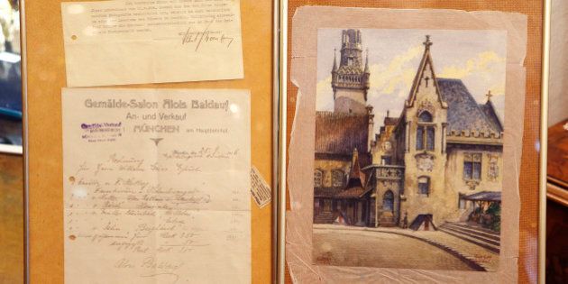 The Wednesday, Nov. 19, 2014 photo shows a picture titled âThe Old City Hallâ, right, that - as the auction house said - was painted by Adolf Hitler and the original bill of sale and a signed letter, left, from Hitlerâs adjutant Albert Bormann, brother of the better-known Martin Bormann in Nuremberg, Germany. The 100-year-old watercolor of Munichâs city hall is expected to fetch at least 50,000 euros (US$ 60,000) at auction this weekend, not so much for its artistic value as for the signature in the bottom left corner. (AP Photo/Michael Probst)