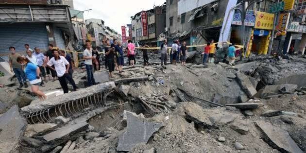 Local residents look at the damage caused by gas explosions in the southern Taiwan city of Kaohsiung on August 1, 2014. A series of powerful gas blasts killed at least 25 people and injured up to 267 in the southern Taiwanese city of Kaohsiung, overturning cars and ripping up roads as terrified residents fled an inferno. AFP PHOTO / SAM YEH (Photo credit should read SAM YEH/AFP/Getty Images)
