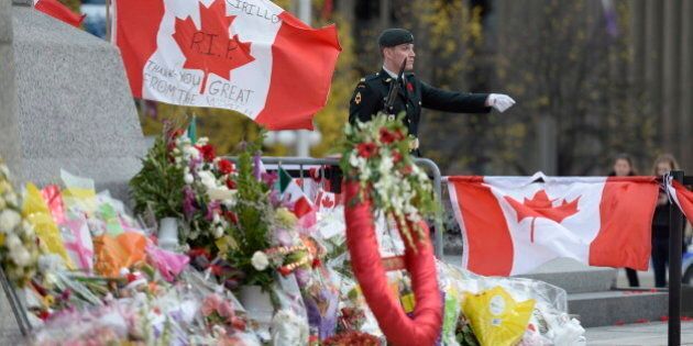 An honour guard mans the National War Memorial in Ottawa on Friday, Oct. 31, 2014. Public Works and Government Services Canada announced Friday it will begin to remove flowers and mementos at the memorial on Sunday in order to prepare the site for the November 11 annual Remembrance Day ceremony. THE CANADIAN PRESS/Adrian Wyld