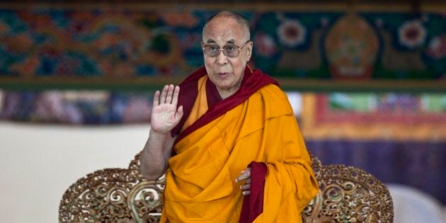 Tibetan spiritual leader the Dalai Lama gestures to devotees before he starts teaching on the fifth day of Kalachakra near Leh, India, Monday, July 7, 2014. Buddhist devotees from across the globe have arrived in this Himalayan region of Ladakh to attend the âKalachakraâ or Wheel of Time initiations by the Dalai Lama that began Thursday. (AP Photo/Tsering Topgyal)