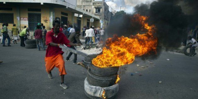 Protesters block a street with burning tires and barricades in the center of Port-au-Prince on December 5, 2014. Protesters marched through the streets calling for the resignation of the Haitian leader Michel Martelly and the Prime Minister, Laurent Lamothe. In the center of the city the demonstrators protested in front of the National Palace and after blocked some streets nearby to the palace with burning tires and barricades. AFP PHOTO/Hector RETAMAL (Photo credit should read HECTOR RETAMAL/AFP/Getty Images)
