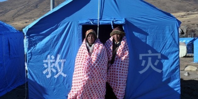 Two Tibetan women stand outside a makeshift tent at a relief centre in Kangding on November 23, 2014 after a quake struck 39 kilometres (24 miles) northwest of Kangding in the mountainous west of Sichuan province on November 22. The death toll from a 5.9 magnitude earthquake that struck a remote part of China's southwest rose to five, as media reported the injured have all been successfully rescued. CHINA OUT AFP PHOTO (Photo credit should read STR/AFP/Getty Images)