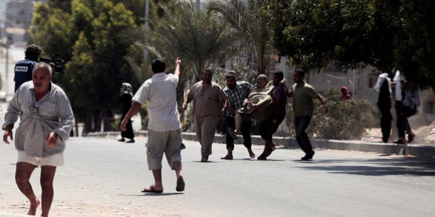 GAZA CITY, GAZA - AUGUST 23: Palestinians carry a woman wounded by Israeli forces in Gaza city, Gaza on 23 August, 2014. Israeli forces hit a building belonging to Dahduh family in Zeytun district of Gaza and people around the building run away from the Zeytun district. (Photo by Mustafa Hassona/Anadolu Agency/Getty Images)