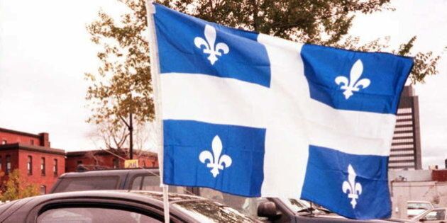 MONTREAL, CANADA: A car stopped at a street light in Montreal waves the flag of the province of Quebec the day of the referendum on Quebec separatism 30 October. Quebecers vote 30 October on whether they want to remain in Canada or form their own nation. AFP PHOTO (Photo credit should read CARLO ALLEGRI/AFP/Getty Images)