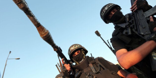 GAZA CITY, GAZA - AUGUST 27: Members of the Ezzeddin al-Qassam Brigades, the armed wing of Palestinian resistance faction Hamas, stand guard during their press statement in the Shujaya neighborhood in eastern Gaza City on August 27, 2014. (Photo by Ashraf Amra/Anadolu Agency/Getty Images)