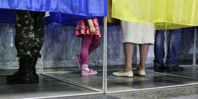 KIEV, UKRAINE - MAY 25: People vote inside a row of polling booths on May 25, 2014 in Kiev, Ukraine. The Ukrainian Presidential election is taking place today. (Photo by Dan Kitwood/Getty Images)
