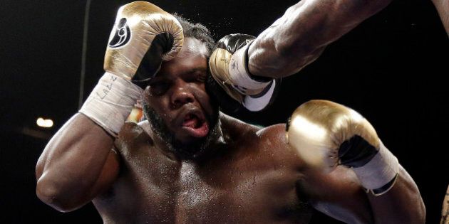 Bermane Stiverne takes a punch from Deontay Wilder during their WBC heavyweight championship boxing match Saturday, Jan. 17, 2015, in Las Vegas. Wilder won by unanimous decision. (AP Photo/Isaac Brekken)