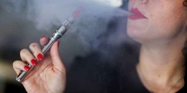 MIAMI, FL - APRIL 24: Julia Boyle enjoys an electronic cigarette as she waits for customers at the Vapor Shark store on April 24, 2014 in Miami, Florida. Brandon Leidel, CEO, Director of OperationsVapor Shark, said he welcomes the annoucement by the Food and Drug Administration that they are proposing the first federal regulations on electronic cigarettes, which would ban sales of the popular devices to anyone under 18 and require makers to gain FDA approval for their products. (Photo by Joe Raedle/Getty Images)