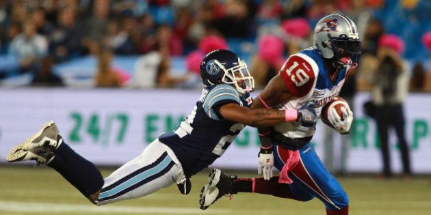 TORONTO, ON - OCTOBER 18: Evan McCollough #24 of the Toronto Argonauts makes a tackle on S.J. Green #19 of the Montreal Alouettes during their game at Rogers Centre on October 18, 2014 in Toronto, Canada. (Photo by Dave Sandford/Getty Images)