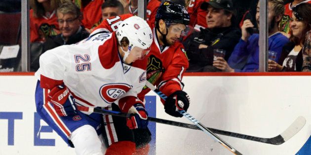 Montreal Canadiens left wing Jacob de la Rose (25), left, and Chicago Blackhawks center Marcus Kruger (16) battle for the puck during the first period of a preseason NHL hockey game in Chicago, Wednesday, Oct. 1, 2014. (AP Photo/Nam Y. Huh)