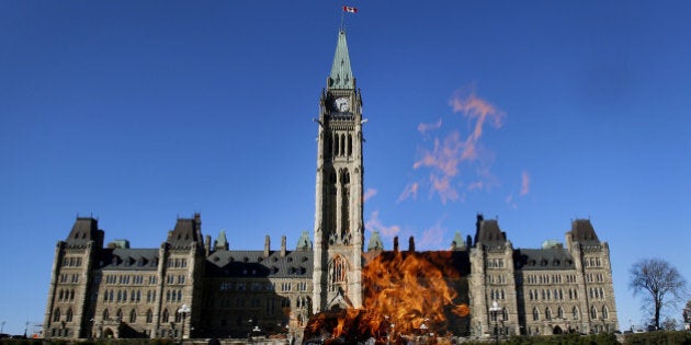 The Centennial Flame stands in front of the Centre Block and Peace Tower of Parliament on Parliament Hill in Ottawa, Ontario, Canada, on Tuesday, Oct. 29, 2013. Stephen Poloz, governor of the Bank of Canada, said the central bank is modifying the format of its quarterly monetary policy reports to explicitly capture uncertainty in its outlook. Photographer: Patrick Doyle/Bloomberg via Getty Images