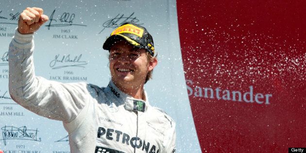 Mercedes' German driver Nico Rosberg celebrates his victory on the podium at the Silverstone circuit in Silverstone on June 30, 2013 after the British Formula One Grand Prix. AFP PHOTO / TOM GANDOLFINI (Photo credit should read Tom Gandolfini/AFP/Getty Images)